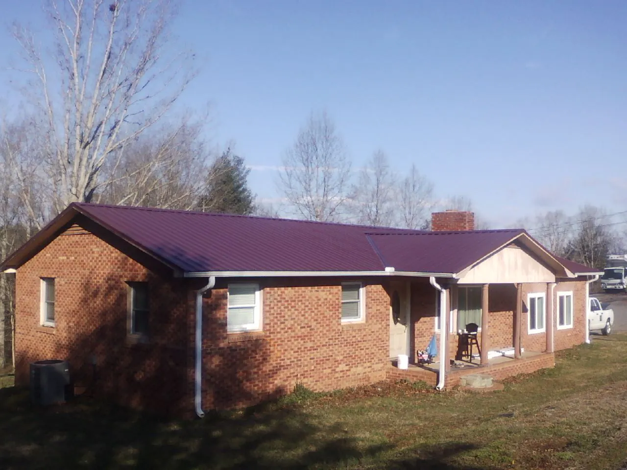 Burgundy metal roof on a brick ranch home with a new addition in Rippey