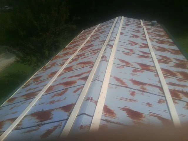 Rusted metal roof panels with new wood purlins before replacement — Storm Damage Roof Repair in Rippey by Roofing Brothers