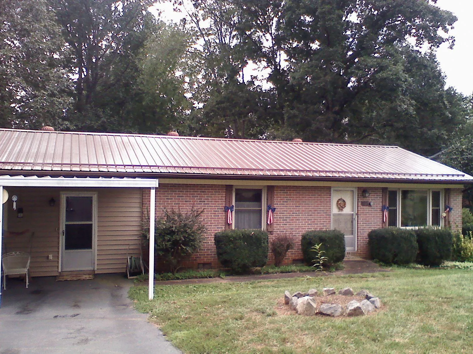 Bronze metal roof and carport on a brick ranch home — Roof Repair work by our crew in Rippey